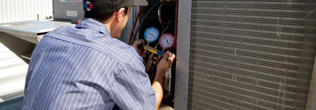HVAC technician servicing a condenser unit in Lower Makefield